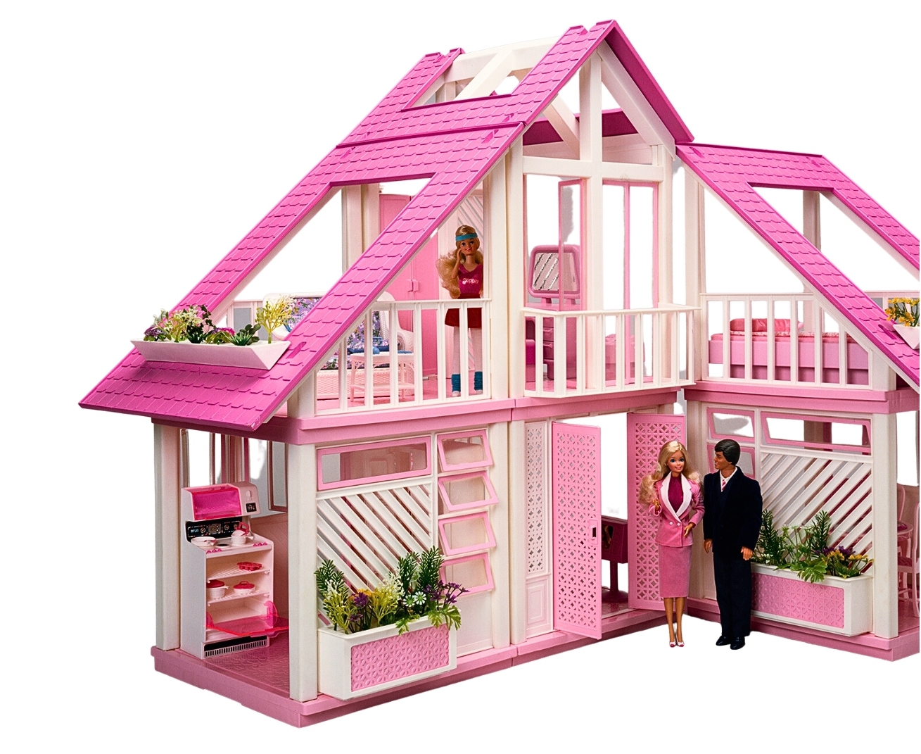 Barbie and Ken stand beside the 1980s Dreamhouse, which has pink and white infrastructure